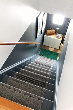 the stairs are made of metal wire and have green carpeting on them, along with an area rug