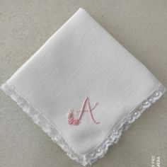 embroidered monogrammed handkerchief on white linen with pink thread and crochet border