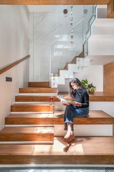 a woman sitting on some stairs reading a book