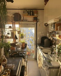 a narrow kitchen with lots of pots and pans hanging from the ceiling over the sink