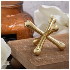 a gold cross ring sitting on top of a wooden table