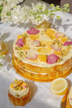 there is a cake with flowers on it and lemons next to the cake slices