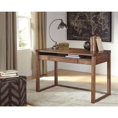 a wooden desk with a lamp and books on it