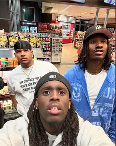 three young men are standing in a store