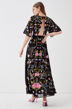 Introducing our stunning black floral dress, perfect for any occasion. This maxi dress features a high neckline and short angel sleeves, providing a flowy and elegant look. The dress is embroidered with beautiful floral patterns, adding a touch of sophistication to your outfit. The long length of the dress creates a graceful silhouette, making it perfect for formal events or a night out. Angel Sleeves, Black Floral Dress, Angel Sleeve, Embroidered Maxi Dress, Floral Dress Black, Floral Patterns, High Neckline, Embroidered Dress, Long Length