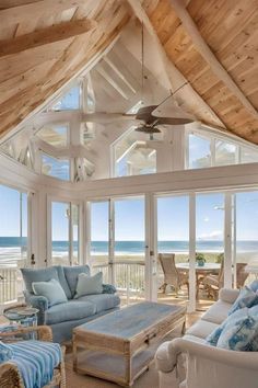 a living room filled with furniture next to an ocean front window covered in wooden planks