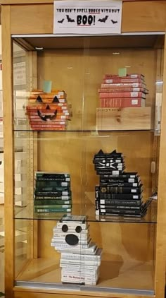 a display case filled with lots of books and halloween decorations on top of glass shelves