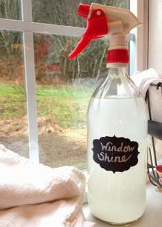 a bottle of window shiner sitting on top of a table next to a window