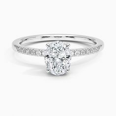 an oval cut diamond engagement ring with pave set shoulders