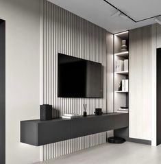 a modern living room with white walls and black entertainment center on the wall, built in bookshelves