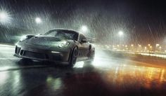 a sports car driving in the rain at night