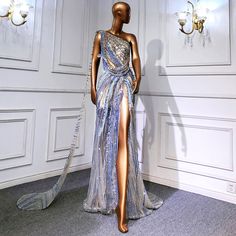 5-7 weeks processing and shipping time This design is from our Luxe x Bougie Glitter collection. This extravagant blue and gold one shoulder gown is fit for a princess! Handed beaded with sequins and featuring dramatic draping, a high front slit and an embellished train. Color may vary due to lighting Swarovski Dress, Crystal Gown, Luxury Gowns, Gold Sequin Gown, Celebrity Style Dresses, Crystal Wedding Dress, Celebrity Gowns, High Fashion Dresses, Crystal Dress