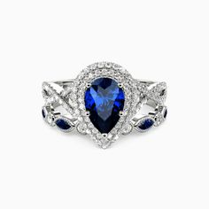 a blue and white diamond ring with leaves on the sides, surrounded by diamonds in silver