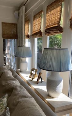 a living room filled with lots of furniture and two lamps on top of a table