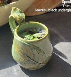 there is a green cup with leaves on it