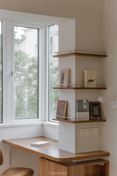 a desk and chair in front of a window with books on the shelves next to it