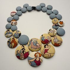 a necklace made out of buttons with people on the front and back, all in different colors