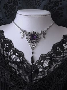 Elevate your gothic ensemble with our exquisite necklace. This stunning piece features intricate floral carvings and a mesmerizing purple gemstone, exuding an air of mystery and elegance. The rhinestone pendant adds a touch of glamour, making it a versatile accessory for both casual and formal occasions. Embrace the allure of Gothic fashion with this unique and timeless necklace, perfect for adding a touch of vintage charm to your wardrobe.  Please note that this product includes only the neckla Gothic Filigree Pendant Jewelry, Gothic Purple Metal Jewelry, Gothic Metal Necklaces With Jewels, Gothic Pendant Necklace With Jewels, Gothic Purple Necklace For Party, Gothic Crystal Jewelry For Gift, Purple Gothic Necklace For Party, Gothic Purple Jewelry Gift, Gothic Silver Crystal Jewelry