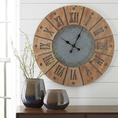 a clock on the wall next to two vases