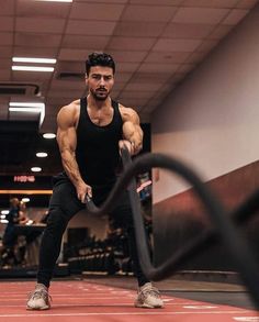 a man is doing exercises with a barbell in the middle of an indoor gym