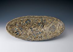 a decorative bowl with starfishs and seaweed on it