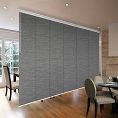 a dining room with a table and chairs next to a sliding glass door that has blinds on it