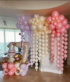 some balloons are hanging from the ceiling in front of a table and chair with an unicorn on it