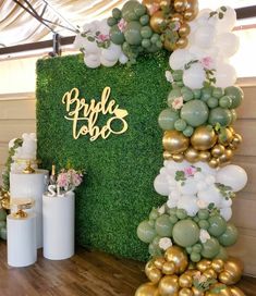 a table topped with balloons and greenery next to a sign that says bride tribe