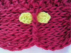 a close up of a knitted object with two buttons on the front of it