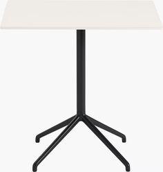 a white table sitting on top of a black metal stand up desk with two legs