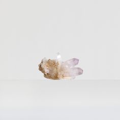 a piece of white rock sitting on top of a table next to a glass vase