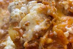 a close up view of some food with cheese and sauce on it's surface