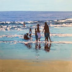 a group of people standing on top of a beach next to the ocean