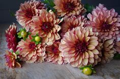 a bunch of pink flowers sitting on top of a wooden table