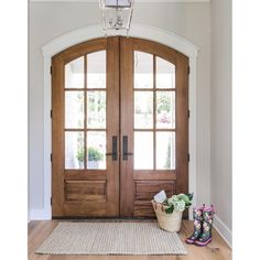 a pair of boots sitting on top of a rug in front of a wooden door