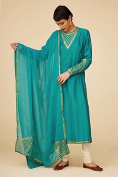 Teal blue full sleeves straight kurta in chanderi base with sequin tikki jaal embroidery on the neckline, sleeves hem and borders. Paired with ivory cotton churidar and embroidered viscose organza dupatta.
Components: 3
Pattern: Embroidery
Type Of Work: Sequin Tikki Jaal
Neckline: Round
Sleeve Type: Full
Fabric: Kurta: Chanderi, Dupatta: Viscose Organza, Churidar: Cotton
Color: Blue
Other Details: 
Length:
Kurta: 46inches
Churidar: 58inches
Dupatta: 2.5metres
Occasion: Puja - Aza Fashions Navratri Unstitched Long Sleeve Suit With Mirror Work, Long Sleeve Kurta With Dupatta In Chinon, Long Sleeve Slub Silk Anarkali Set With Mirror Work, Long Sleeve Chinon Kurta With Dupatta, Long Sleeve Chinon Anarkali Set With Dupatta, Traditional Long Sleeve Dola Silk Dress With Mirror Work, Festive Long Sleeve Churidar With Mirror Work, Festival Dola Silk Sharara, Georgette Unstitched Straight Kurta Suit With Embroidered Border