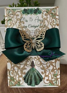 a card with a green bow and gold sequins on it, sitting on top of a wooden table