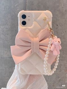 an iphone case with a pink bow and pearls