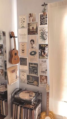 there is a guitar and some records on the wall in this room with many pictures