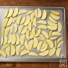 sliced potatoes on a baking sheet ready to be cooked in the oven for roasting