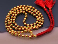 A Japamala or mala is a string of prayer beads commonly used in Hinduism, Jainism, Sikhism, Buddhism and Shintō for the spiritual practice known in Sanskrit as japa. The rosary is usually made from 108 beads, though other numbers are also used. Malas are used for keeping count while reciting, chanting, or mentally repeating a mantra or the name or names of a Deity.20karat gold beads strung in a cotton thread with knot within each gold beads to make this necklace.Metal-20karat yellow gold.Type- N Gold Jewelry With 108 Round Beads, Gold Jewelry With Hand-knotted Round Beads, Gold Necklaces With 8mm Beads For Spiritual Style, Traditional Jewelry With 8mm Beads For Meditation, Traditional 8mm Beads Jewelry For Meditation, Traditional Jewelry For Meditation With 8mm Beads, Spiritual Round Beads Jewelry For Puja, Spiritual Round Beads Mala For Puja, Spiritual Mala With Round Beads For Puja