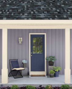 a blue front door sitting on top of a porch next to a chair and potted plants