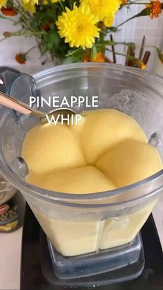 a bowl filled with chunks of pineapple next to flowers