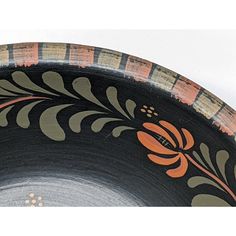 an orange and black bowl with designs on it