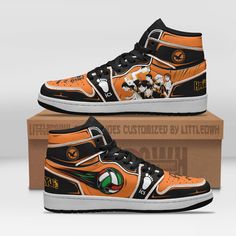 an orange and black high top sneaker with mickey mouse on the side, next to a cardboard box