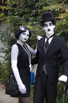 two people dressed up in black and white are standing next to each other with makeup on their faces