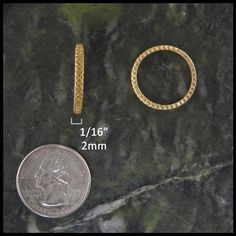 two different types of gold rings next to a dime