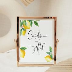 a sign that says cards and gifts with lemons on the front, in gold frame