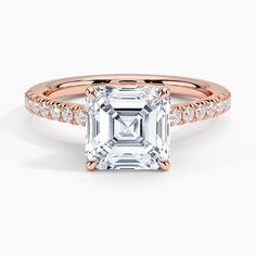 an emerald cut diamond ring with diamonds on the band