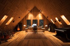 a room with wooden walls and lots of musical instruments on the floor next to a piano